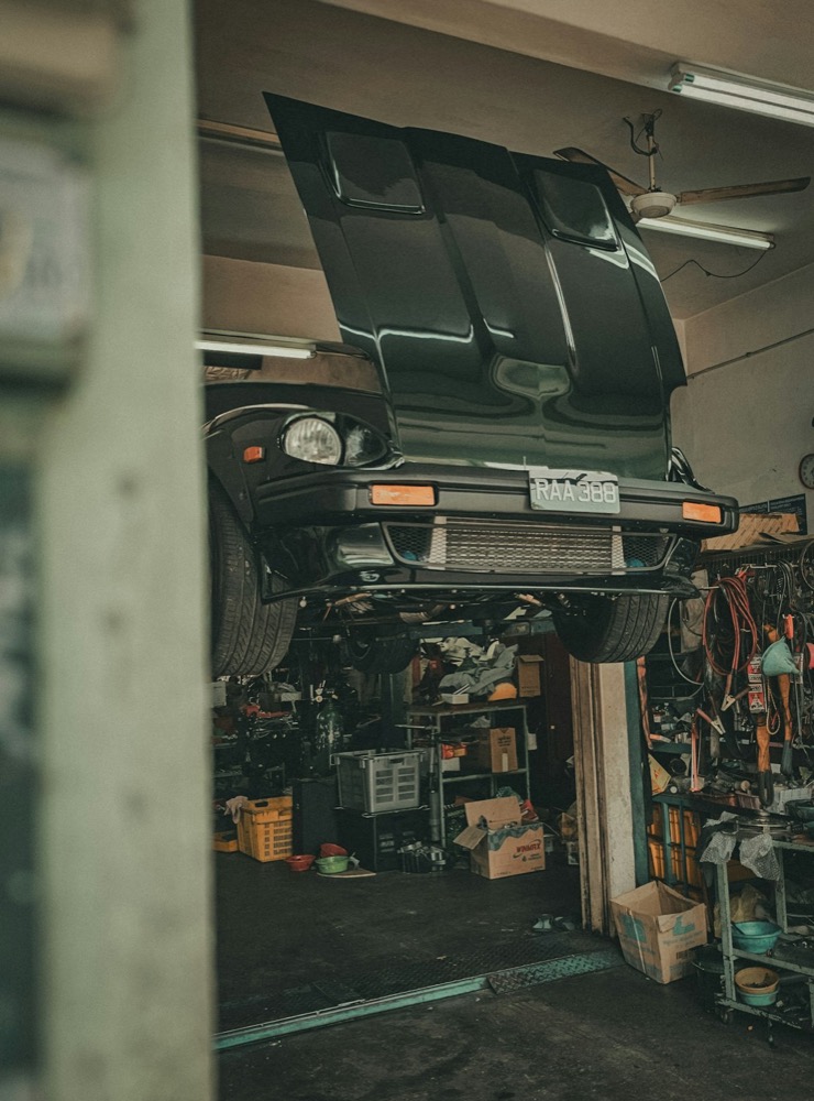 Classic car raised on a lift with the hood open