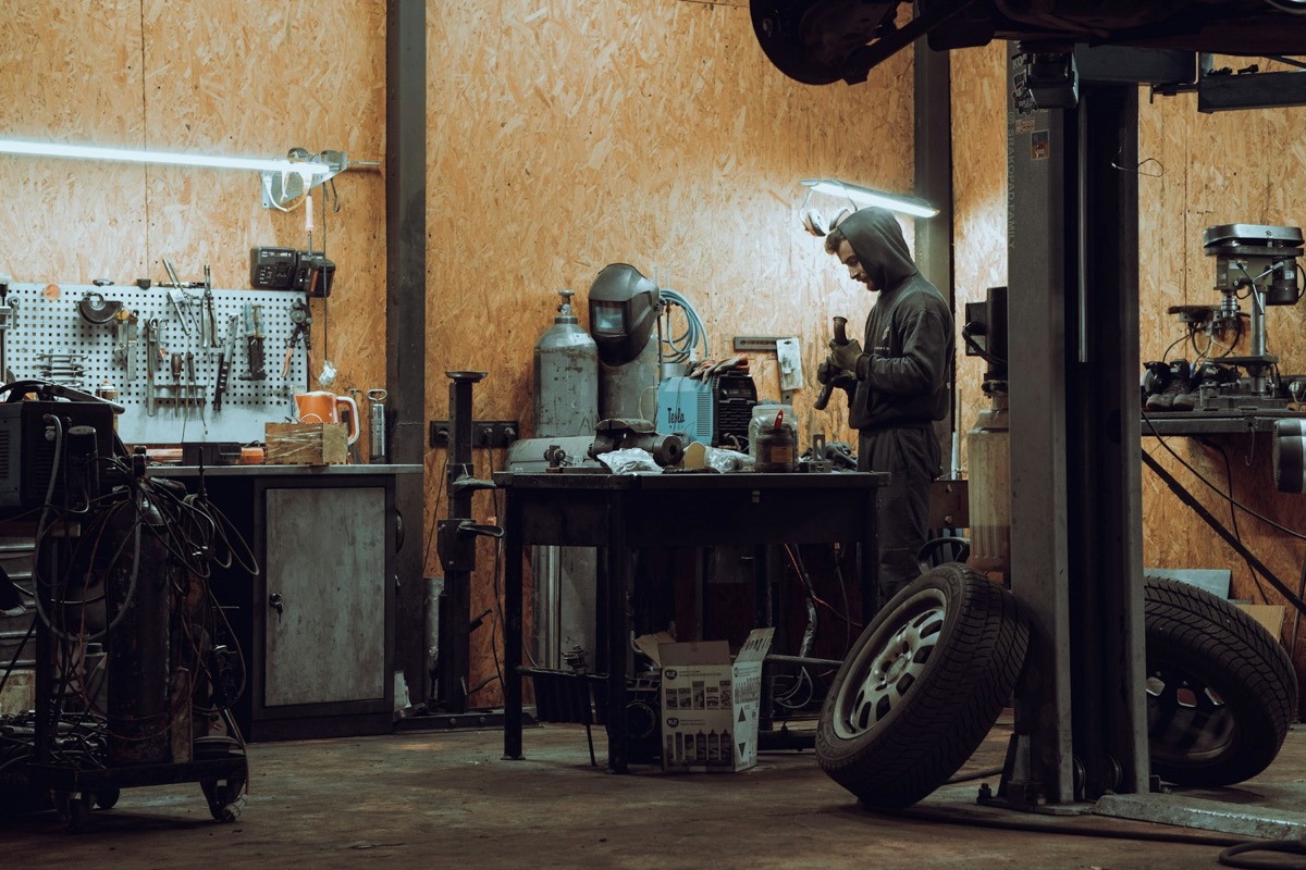 Workshop bench with tools, welder, and a wheel waiting to go back on